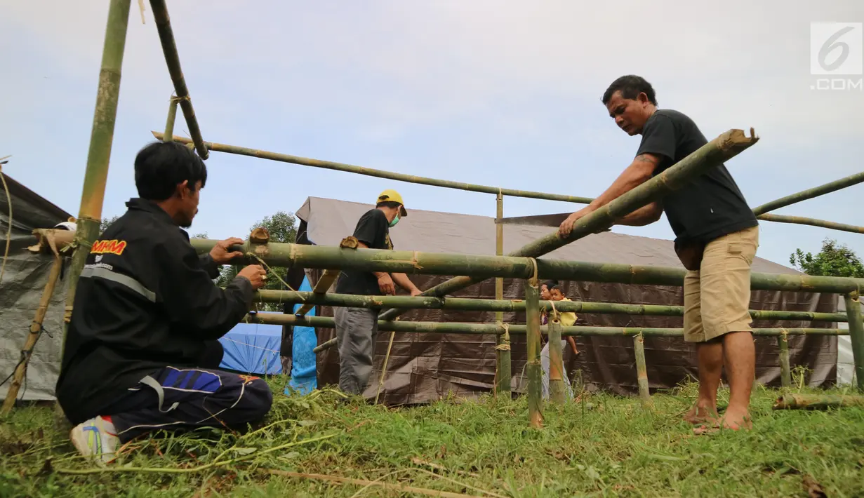 Warga menata bambu untuk membangun kamp pengungsian Gunung Agung di lahan milik dinas pertanian, Karangasem, Bali, Senin (27/11). BNPB mengatakan ada 22 desa yang warganya harus mengungsi terkait status awas Gunung Agung. (Liputan6.com/Andi Jatmiko)
