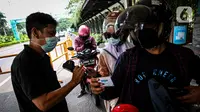 Petugas memeriksa kartu vaksin COVID-19 di Taman Impian Jaya Ancol, Jakarta, Sabtu (11/10/2021).  Uji coba pembukaan itu berdasarkan Kepgub Nomor 1072 Tahun 2021 tentang PPKM Level 3 yang ditandatangani oleh Gubernur DKI Jakarta Anies Baswedan pada 6 September 2021 lalu. (Liputan6.com/Faizal Fanani)