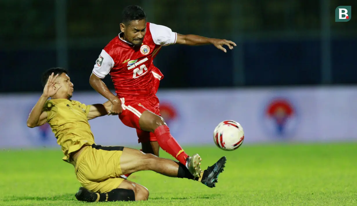 Gelandang Bhayangkara Solo FC, TM Ichsan (kiri) berebut bola dengan gelandang Persija Jakarta, Ramdani Lestaluhu dalam laga matchday ke-3 Grup B Piala Menpora 2021 di Stadion Kanjuruhan, Malang, Rabu (31/3/2021). (Bola.com/M Iqbal Ichsan)