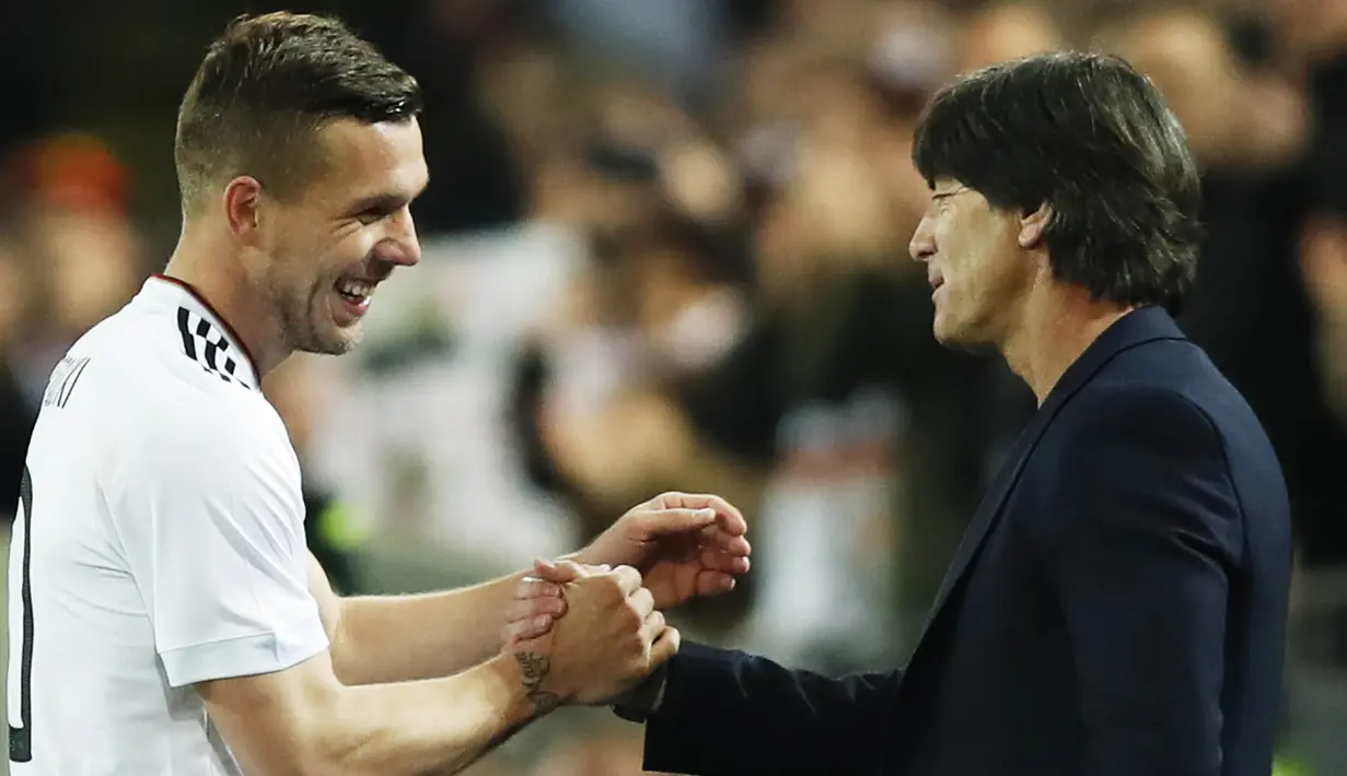 Gelandang Jerman, Lukas Podolski, berbincang dengan pelatih Jerman, Joachim Loew. Podolski turut menjadi bagian dari skuat Jerman saat menjuarai Piala Dunia 2014 di Brasil. (EPA/Friedmann Vogel)
