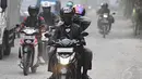 Pengendara melintasi jalan yang dipenuhi debu tebal di Jalan Kemukus, Tamansari, Jakarta Barat, Senin (24/11/2014). (Liputan6.com/Faizal Fanani)