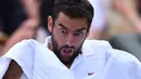 Mimik wajah Marin Cilic saat menggunakan handuk pada perempat final melawan Gilles Muller di The All England Lawn Tennis Club, London, (11/7/2017). (AFP/Glyn Kirk)