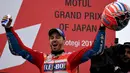 Pembalap Ducati, Andrea Dovizioso merayakan kemenangannya di atas podium usai memenangi MotoGP Jepang di sirkuit Motegi (15/10). Pembalap Ducati ini kini hanya 11 angka tertinggal dari Marc Marquez. (AFP Photo/Toshifumi Kitamura)