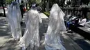 Sejumlah wanita mengenakan gaun dan kerudung putih  dengan noda darah melintas di jalan Mexico City, Meksiko (7/5). Wanita ini mengenakan gaun untuk menggelar aksi"Las 43 Lloronas" yang bertujuan  menuntut kasus hilangnya 43 siswa. (AFP Photo/Yuri Cortez)