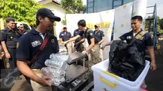 Petugas Bea Cukai menjaga barang bukti sabu seberat 33 kg saat rilis di Jakarta, Kamis (23/6). Bea Cukai bersama BNN menggagalkan penyelundupan 33 kg sabu yang dikemas dalam tiga moulding stainless stell. (Liputan6.com/Helmi Fithriansyah)