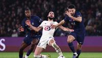 Gelandang Lille, Nabil Bentaleb (tengah), terjatuh ke lapangan saat berebut bola dengan pemain Paris Saint-Germain, Willian Pacho (kiri), dan, Gonçalo Ramos (kanan), dalam pertandingan Liga Prancis di Stadion Parc des Princes, Paris, Jumat (17/1/2026) dini hari WIB. (AFP/Anne-Christine Poujoulat)