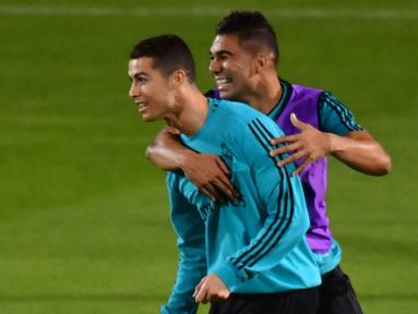 Pemain Real Madrid, Cristiano Ronaldo bercanda dengan rekannya Casemiro saat latihan di Stadion NY University Abu Dhabi, UAE, Senin (11/12/2017). Los Blancos bersiap jelang semifinal FIFA Club World Cup. (AFP/Giuseppe Cacace)