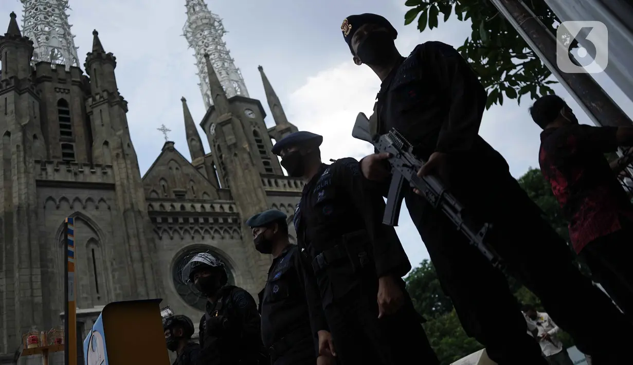 Personel Brimob melakukan penjagaan saat penyisiran di Gereja Katedral, Jakarta, Jumat (24/12/2021). Polda Metro Jaya bersama Satuan Brimob melakukan sterilisasi sejumlah gereja guna memastikan bebas dari bahan berbahaya. (Liputan6.com/Faizal Fanani)