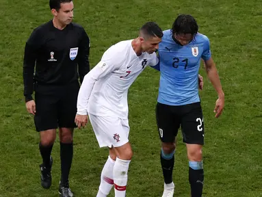 Penyerang Portugal, Cristiano Ronaldo membantu Edinson Cavani yang Cedera keluar lapangan saat pertandingan babak 16 besar Piala Dunia 2018 di Stadion Fisht di Sochi, Rusia (30/6). Cavani cedera kisaran menit ke 70. (AP Photo/Darko Vojinovic)