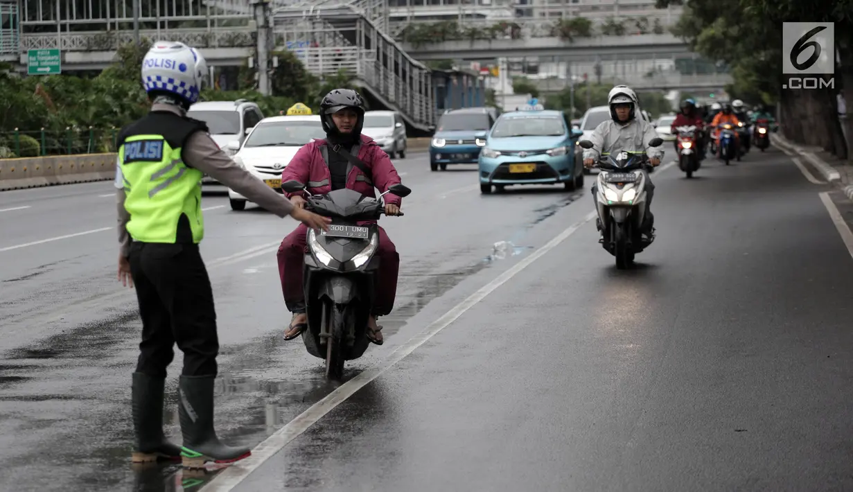 Polisi memberhentikan pengendara motor yang melanggar aturan jalur khusus di Jalan MH Thamrin, Jakarta Pusat, Kamis (8/2). Sosialisasi jalur khusus sepeda motor ini telah dilakukan polisi pada 29 Januari - 4 Febuari 2018 lalu. (Liputan6.com/Arya Manggala)