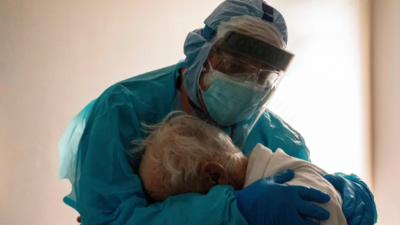 Dr. Joseph Varon menghibur pasiennya di unit perawatan intensif COVID-19 di United Memorial Medical Center di Houston, Texas. (Photo credit: Go Nakamura/Getty Images/AFP)