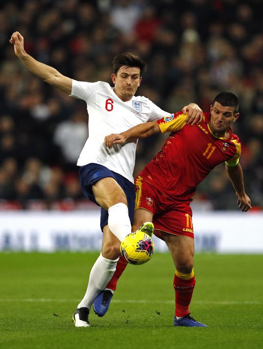 Bek Inggris, Harry Maguire (kiri) berebut bola dengan penyerang Montenegro, Fatos selama pertandingan Grup A Kualifikasi Piala Eropa 2020 di Stadion Wembley di London (14/11/2019). Inggris menang telak 7-0 atas Montenegro. (AFP/Adrian Dennis)