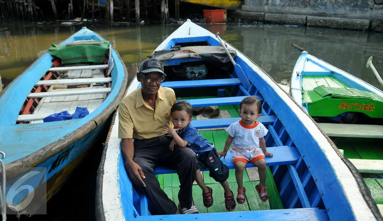Warga berpose di atas sampan di Kampung Aquarium, Jakarta Utara, Senin (28/3). Warga mengaku resah terkait rencana Pemprov DKI Jakarta yang akan melakukan penertiban di kawasan Luar Batang, Penjaringan, Jakarta Utara. (Liputan6.com/Gempur M Surya)