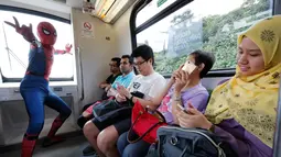Seorang cosplayer berkostum Spider-Man berpose di dalam Light Rail Transit saat acara cosplay di Kuala Lumpur, Malaysia, Sabtu, 8 Juli 2017. Sejumlah tokoh karakter animasi tiba-tiba muncul di tengah-tengah ruang publik. (AP Photo/Vincent Thian)