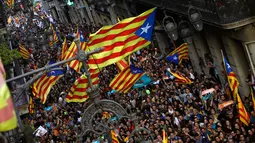 Para pendukung pro-kemerdekaan berkumpul di luar Gedung Palau Generalitat, Barcelona, Jumat (27/10). Parlemen regional Catalonia mendeklarasikan kemerdekaan dari Spanyol melalui pemungutan suara. (AP/Emilio Morenatti)