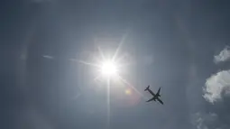 Pesawat komersil melintas dilatari fenomena halo matahari di Meksiko, Sabtu (7/7). Fenomena halo matahari terjadi karena pembiasan kristal es yang berada di sekitar matahari sehingga membentuk cincin pelangi yang mengelilingi matahari (AP/Moises Castillo)