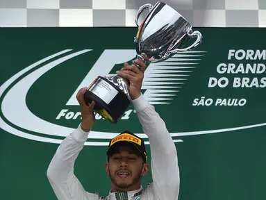  Pebalap Mercedes GP, Lewis Hamilton, menjaga asa untuk mempertahankan gelar juara dunia F1. Ini berkat kemenangan pada balapan F1 GP Brasil, Minggu (13/11/2016), dengan mengalahkan rivalnya, Nico Rosberg. (AFP/Miguel Schincariol)