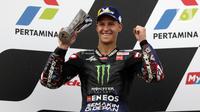 Pembalap Monster Energy Yamaha MotoGP, Fabio Quartararo mengangkat piala posisi kedua Pertamina Mandalika International Street Sirkuit, NTB, Minggu (20/3/2022). Pembalap Red Bull KTM Factory Racing, Miguel Oliveira menempati posisi pertama MotoGP Mandalika 2022. (Liputan6.com/Helmi Fithriansyah)