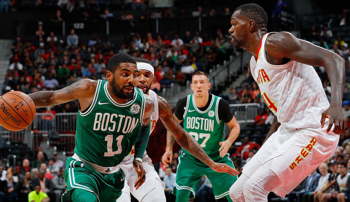 Pebasket Boston Celtics, Kyrie Irving, berusaha melewati pebasket Atlanta Hawks, Dewayne Dedmon, pada laga NBA di Philips Arena, Atlanta, Senin (6/11/2017). Hawks kalah 107-110 dari Celtics. (AFP/Kevin C Cox)