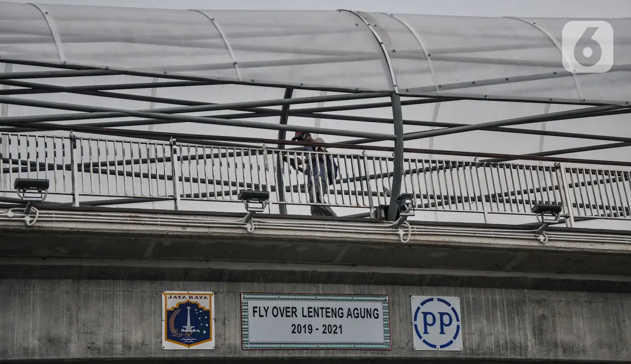 Pejalan kaki saat melintasi jembatan penyeberangan orang (JPO) Flyover Tapal Kuda Lenteng Agung, Jakarta, Minggu (29/8/2021). Diketahui JPO ini telah rampung sejak awal Agustus namun belum tahu kapan akan diresmikan oleh Gubernur DKI Jakarta Anies Baswedan. (merdeka.com/Iqbal S Nugroho)