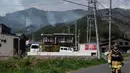 Meski demikian, tidak ada korban jiwa yang dilaporkan. Tampak dalam foto, seorang petugas pemadam kebakaran berjalan di jalan raya sementara asap mengepul di latar belakang kota Otsuchi, Prefektur Iwate, Jepang pada Sabtu 25 April 2026. (ANDREW CABALLERO-REYNOLDS/AFP)