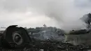 Kepulan asap tampak masih terlihat diantara reruntuhan pesawat Malaysia Airlines MH-17 yang jatuh di Grabovo, wilayah Donetsk, Ukraina , Kamis (17/7/14). (REUTERS/Maxim Zmeyev)