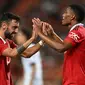 Bruno Fernandes (kiri) merayakan gol Anthony Martial saat Manchester United (MU) bertemu Liverpool pada laga persahabatan di Rajamangala Stadium, Selasa (12/7/2022). (AFP/Manan Vatsyayana)