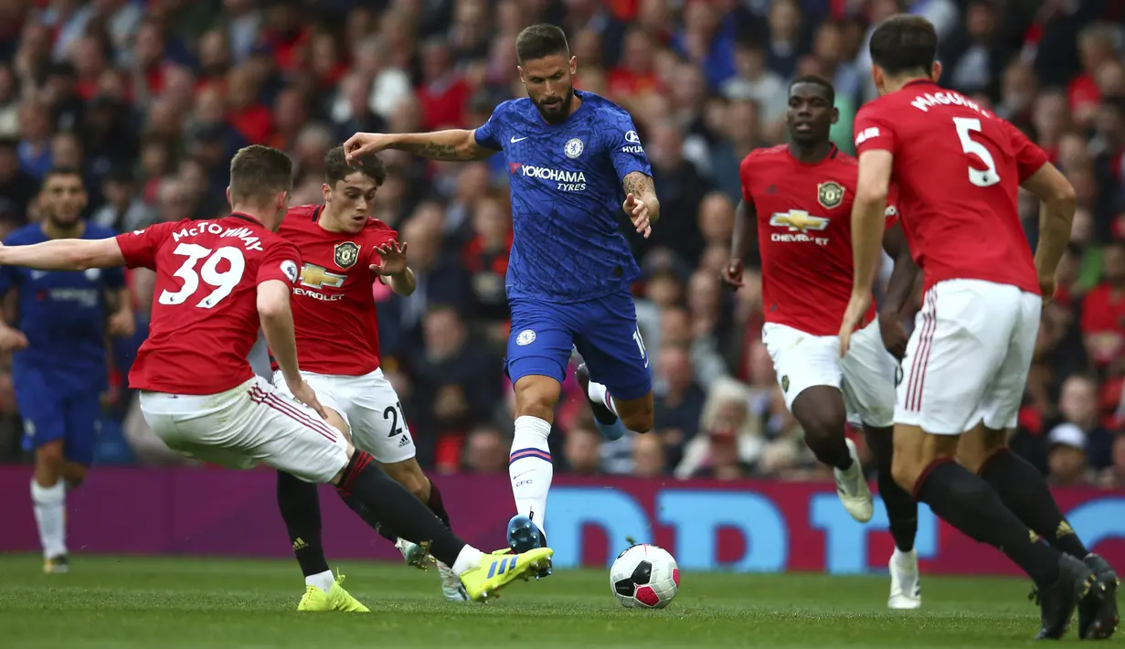 Striker Chelsea, Olivier Giroud (tengah) menggiring bola dari kawalan pemain Manchester United pada pertandingan Liga Inggris di Old Trafford (11/8/2019). MU menang telak 4-0 atas Chelsea. (AP Photo/Dave Thompson)