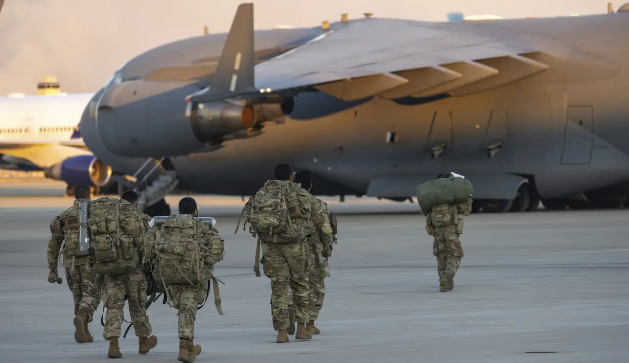 Anggota Divisi Lintas Udara ke-82 Angkatan Darat AS berjalan di landasan Lapangan Paus menjelang penempatan ke Polandia dari Fort Bragg, AS, 14 Februari 2022. Mereka termasuk di antara tentara AS yang dikirim untuk NATO karena khawatir Rusia akan menyerang Ukraina. (AP Photo/Nathan Posner)