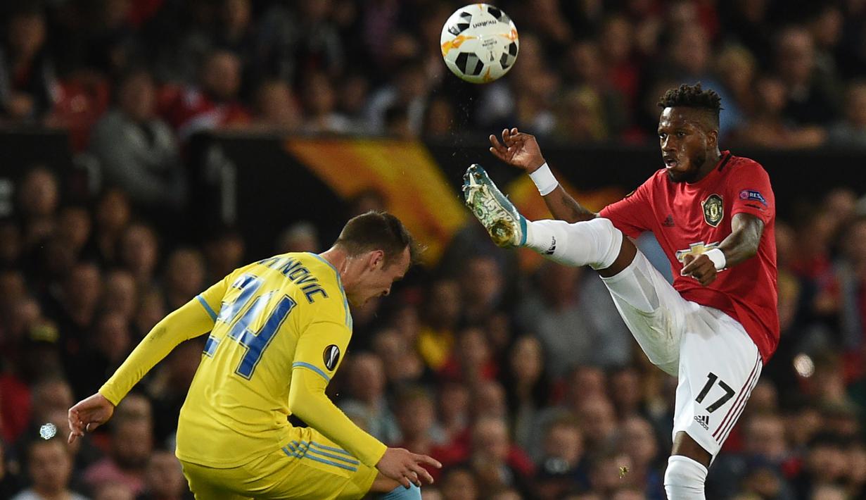 Gelandang Manchester United, Fred, menghindari penjagaan bek Astana, Luka Simunovic, pada laga Europa League di Stadion Old Trafford, Manchester, Kamis (19/9). MU menang 1-0 atas Astana. (AFP/Oli Scarff)