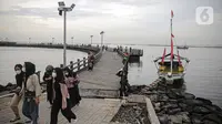 Pengujung berwisata di Pantai Ancol, Jakarta, Rabu (28/12/2022). Isu cuaca yang kurang bersahabat pada hari ini, tidak menyurutkan keinginan warga menghabiskan libur untuk berwisata di kawasan wisata Ancol. (Liputan6.com/Faizal Fanani)