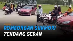 Seorang mengetuk jendela, sementara seorang lainnya menendang bagian depan mobil.