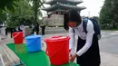Seorang siswa yang mengenakan masker mencuci tangannya sebelum memasuki Sekolah Menengah Atas Ryongwang di Pyongyang, Rabu (3/6/2020). Korea Utara membuka kembali sekolah - sekolah pada bulan ini setelah sebelumnya meliburkan karena kekhawatiran penyebaran virus corona. (AP/Jon Chol Jin)
