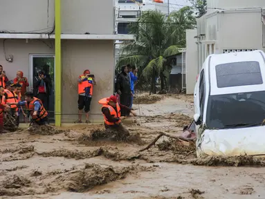 Tim penyelamat memegang tali dalam upaya mengevakuasi kendaraan dan warga yang terjebak banjir di Padang, Provinsi Sumatera Barat pada Kamis 27 November 2025. Badan Penanggulangan Bencana Daerah (BPBD) Kota Padang, Sumatra Barat melaporkan, total 27.433 warga terdampak banjir akibat hujan deras yang mengguyur wilayah tersebut sejak awal pekan lalu. (REZAN SOLEH/AFP)