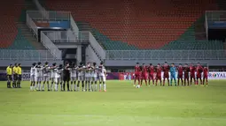 Sebelum dimulainya laga, kedua tim melakukan 'minute of silence' atau mengheningkan cipta. Pertandingan tersebut juga tak dihadiri oleh penonton untuk menghormati korban tragedi yang terjadi di Stadion Kanjuruhan. (Bola.com/Bagaskara Lazuardi)