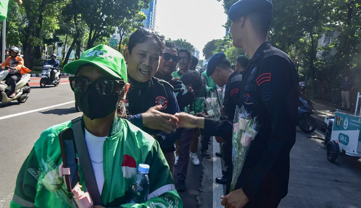 Sepanjang jalan tersebut mawar yang mereka bawa dibagikan kepada aparat TNI dan Polri yang berjaga di kawasan tersebut. (merdeka.com/Arie Basuki)
