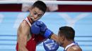 Hook dari petinju asal Puerto Rico, Yankiel Rivera Figueroa mengenai muka dari Saken Bibossinov asal Kazakhstan, dalam pertandingan tinju kelas terbang 52 kg putra Olimpiade Tokyo 2020, Senin (26/7/2021). (Foto: AP/Frank Franklin II)