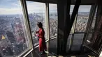 Seorang wanita menikmati pemandangan Kota Manhattan dari ruangan observatorium di lantai 102 Gedung Empire State yang baru direnovasi di New York (10/10/2019). Dibuka untuk umum pada 12 Oktober, ruang observatorium ini berjarak 1.250 kaki di atas permukaan jalan. (AFP Photo/Drew Angerer)
