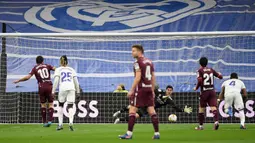 Pemain Real Sociedad Mikel Oyarzabal (kiri) mencetak gol lewat tendangan penalti ke gawang Real Madrid yang dijaga Thibaut Courtois (tengah) pada pertandingan sepak bola Liga Spanyol di Stadion Santiago Bernabeu, Madrid, Spanyol, 5 Maret 2022. Real Madrid menang 4-1. (PIERRE-PHILIPPE MARCOU/AFP)