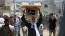 Seorang wanita Palestina membawa bantuan makanan ketika orang-orang kembali ke kamp pengungsi Nuseirat dari titik distribusi Yayasan Kemanusiaan Gaza yang didukung oleh Amerika Serikat (AS) di dekat koridor Netsarim, Jalur Gaza tengah, pada 27 Juli 2025. (Eyad BABA/AFP)