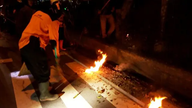 Petugas BPBD memburu tawon baluh yang masih hidup dan berpotensi membahayakan pengguna jalan dan pejalan kaki yang melintas di trotoar. (Foto: Liputan6.com/Muhamad Ridlo/TRC BPBD BMS)