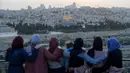 Warga Palestina berkumpul untuk berbuka puasa selama bulan suci Ramadan dengan latar belakang Kota Tua Yerusalem dan kompleks Masjid al-Aqsa yang ditutup selama krisis pandemi coronavirus yang baru di Bukit Zaitun (19/5/2020). (AFP/Ahmad Gharabli)