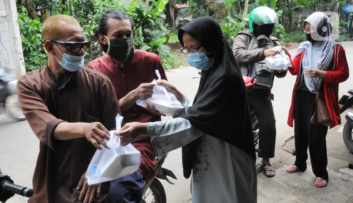 Relawan Yayasan Nasi Jumat (SiJum) Indonesia memberikan makan siang di Warung Makan Gratis Beji, Depok, Jawa Barat, Rabu (9/3/2022). Relawan menyediakan 100 porsi makanan sebagai bentuk kepedulian terhadap masyarakat yang ekonominya terdampak pandemi  COVID-19. (merdeka.com/Arie Basuki)