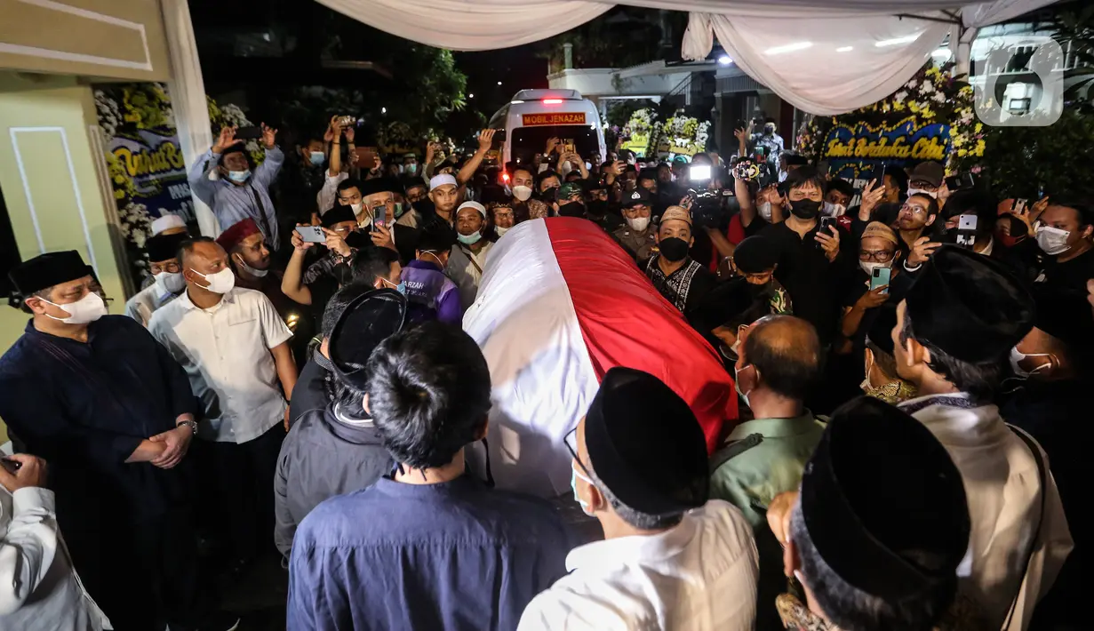 Saudara serta Kerabat mengangkat dan mendorong Peti Jenazah Ketua Dewan Pers Azyumardi Azra di rumah duka di Perumahan Puri Laras II, Cirendeu, Tangerang Selatan, Senin (19/9/2022) tengah malam. Azyumardi Azra meninggal dunia pada Minggu (18/9/2022) di rumah sakit Kedah, Selangor, Malaysia pukul 12.30 waktu setempat, dan rencana akan dimakamkan Selasa (20/9/2022) di Taman Makam Pahlawan (TMP) Kalibata. (Liputan6.com/Johan Tallo)
