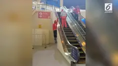 Ada-ada saja yang dilakukan pria ini untuk melewati eskalator, yaitu dengan bergelantungan.