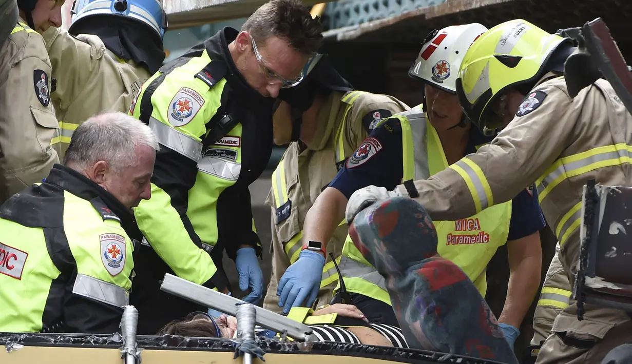 Petugas saat menyelamatkan penumpang dari dalam bus yang menabrak kolong jembatan kereta di Montague, South Melbourne, Australia (22/2). Belum diketahui penyebab tertabraknya bus yang mengangkut 19 orang ini. (REUTERS/Mal Fairclough)