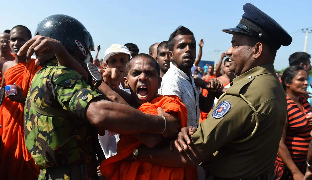 Ekspresi seorang biksu saat melakukan aksi protes di kota pelabuhan selatan Hambantota, Sri Lanka (7/1). Warga menentang rencana tersebut dikarenakan mereka akan mengalami penggusuran di pemukiman mereka. (AFP/Ishara S. Kodikara)