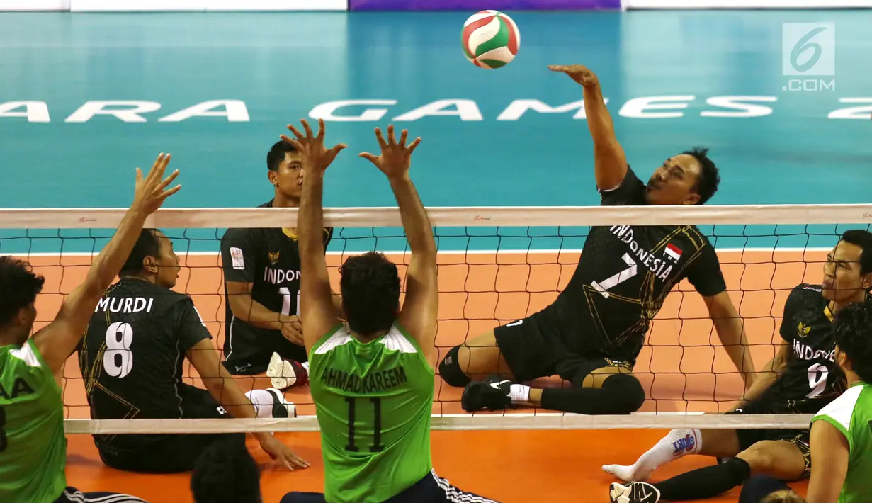 Tim voli duduk putra Indonesia melakukan smash saat berhadapan dengan Iraq pada pertandingan Asian Para Games di GBK, Jakarta, Senin (8/10). Indonesia kalah tiga set langsung dari Iraq. (Merdeka.com/Imam Buhori)
