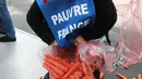 Demonstran membuka plastik berisi wortel ke jalanan depan kantor Kementerian Kesehatan di Paris, Rabu (4/10). Harga sebungkus rokok diperkirakan naik menjadi sekitar Rp 160 ribu perbungkus dari harga awal Rp 110 ribu. (AFP PHOTO/JACQUES DEMARTHON)