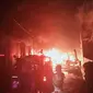 Petugas berupaya memadamkan api yang membakar pabrik daur ulang karet dan empat rumah di Gang Mawar RT 03 RW 05 Padurenan, Mustikajaya, Kota Bekasi. (Liputan6.com/Bam Sinulingga)